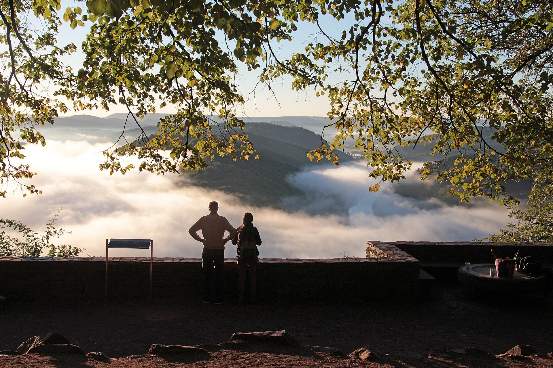 Vue panoramique depuis Sainte-Croix avec lumière douce, silhouettes en contemplation face à la nature